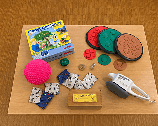 Zwei Kinder spielen auf einer Schaukel und einer Kletterwand.