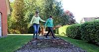 Zwei Frauen gehen auf einem Steg im Garten.